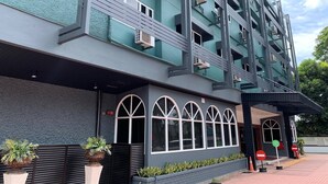 Un edificio de varios pisos con un diseño arquitectónico moderno, que cuenta con una serie de balcones y ventanas grandes.