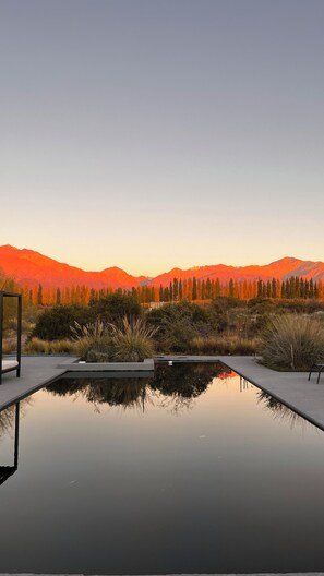 Una piscina al aire libre, sillones reclinables de piscina