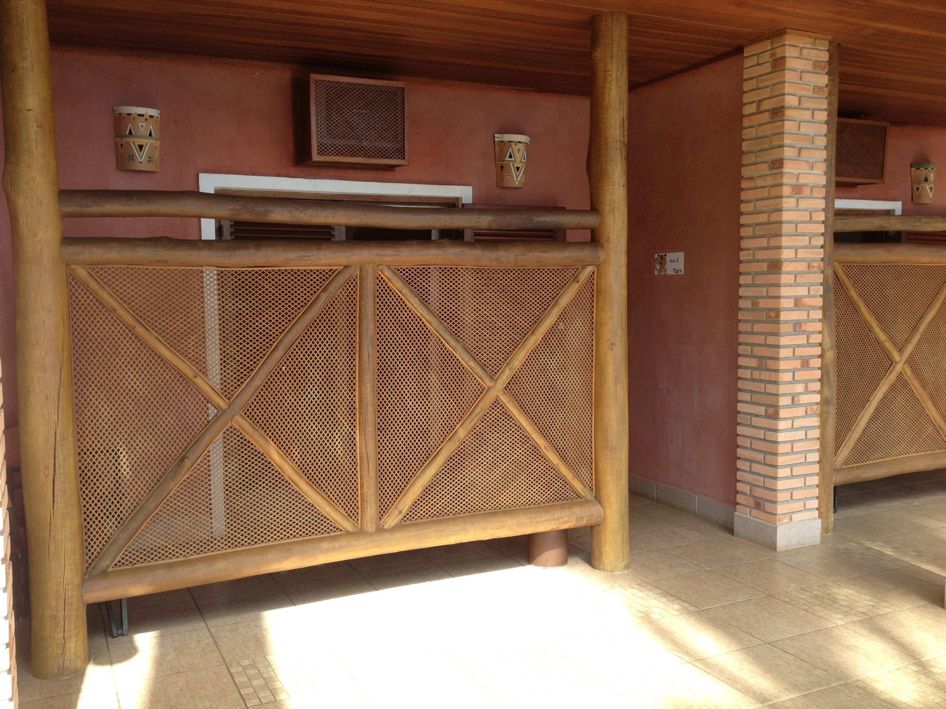 A room with a wooden ceiling, a brick pillar, and a woven partition.