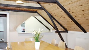 Comedor con una mesa de madera, sillas y una planta en maceta.