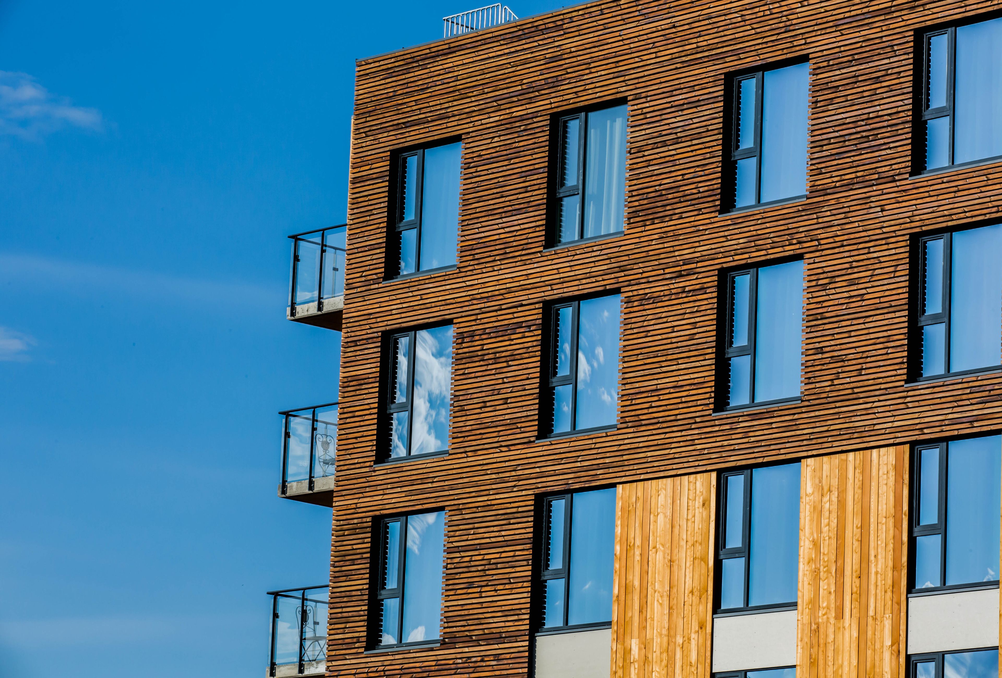 Un edificio de varios pisos con un diseño arquitectónico moderno, que cuenta con ventanas amplias y balcones.