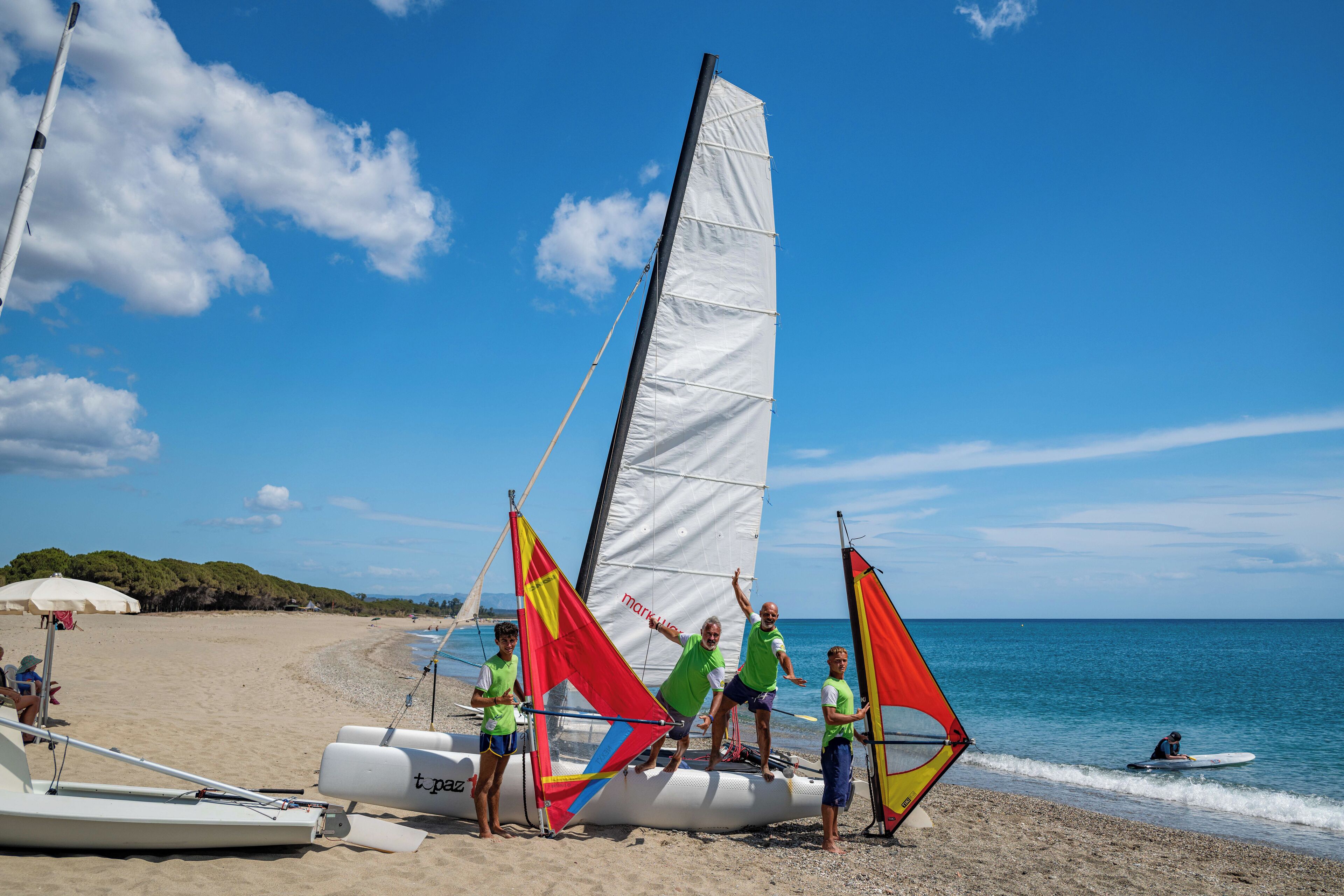 Un voilier avec plusieurs voiles, échoué sur une plage.