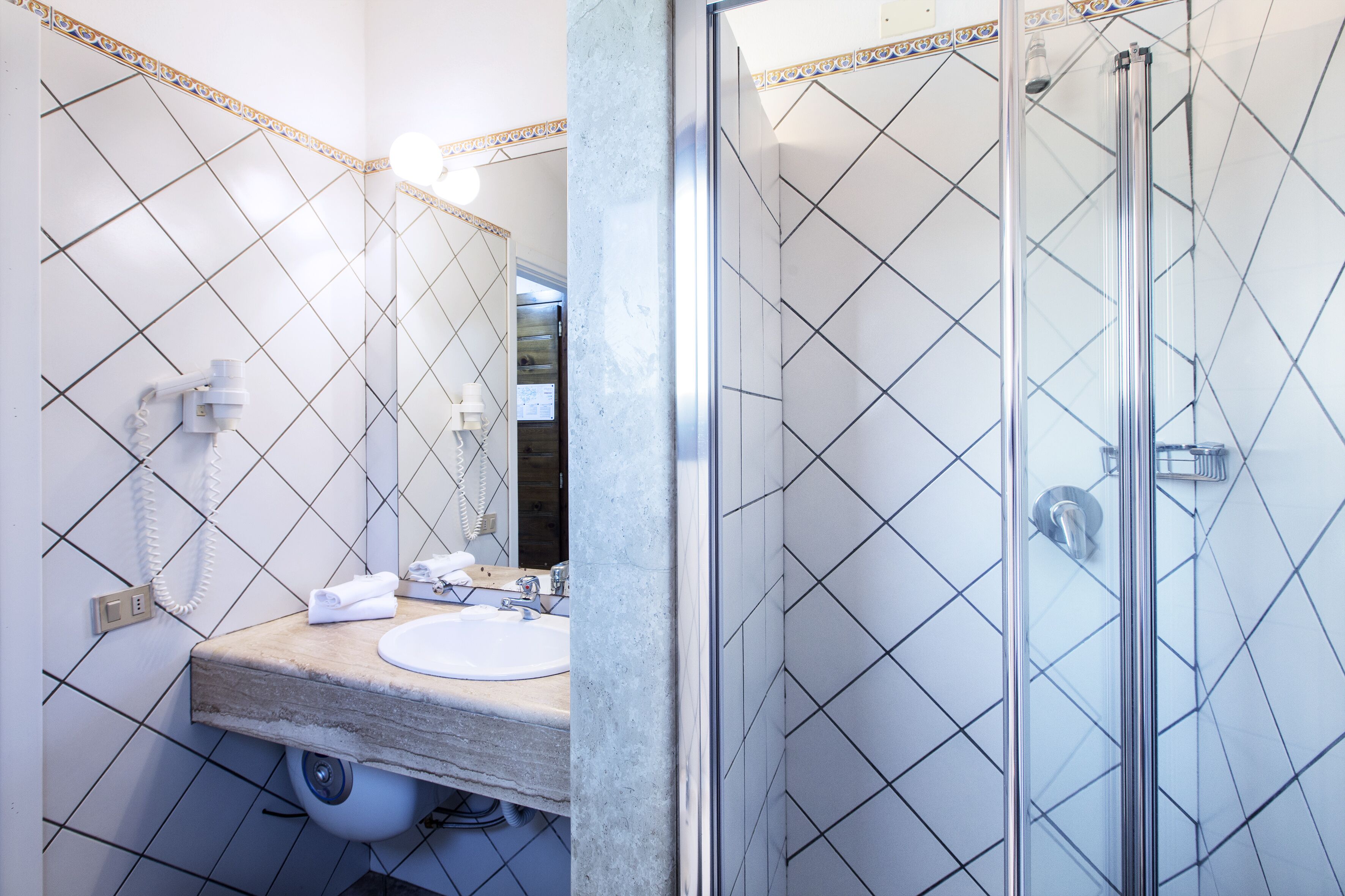 Ein Badezimmer mit Waschbecken, Spiegel und Dusche.