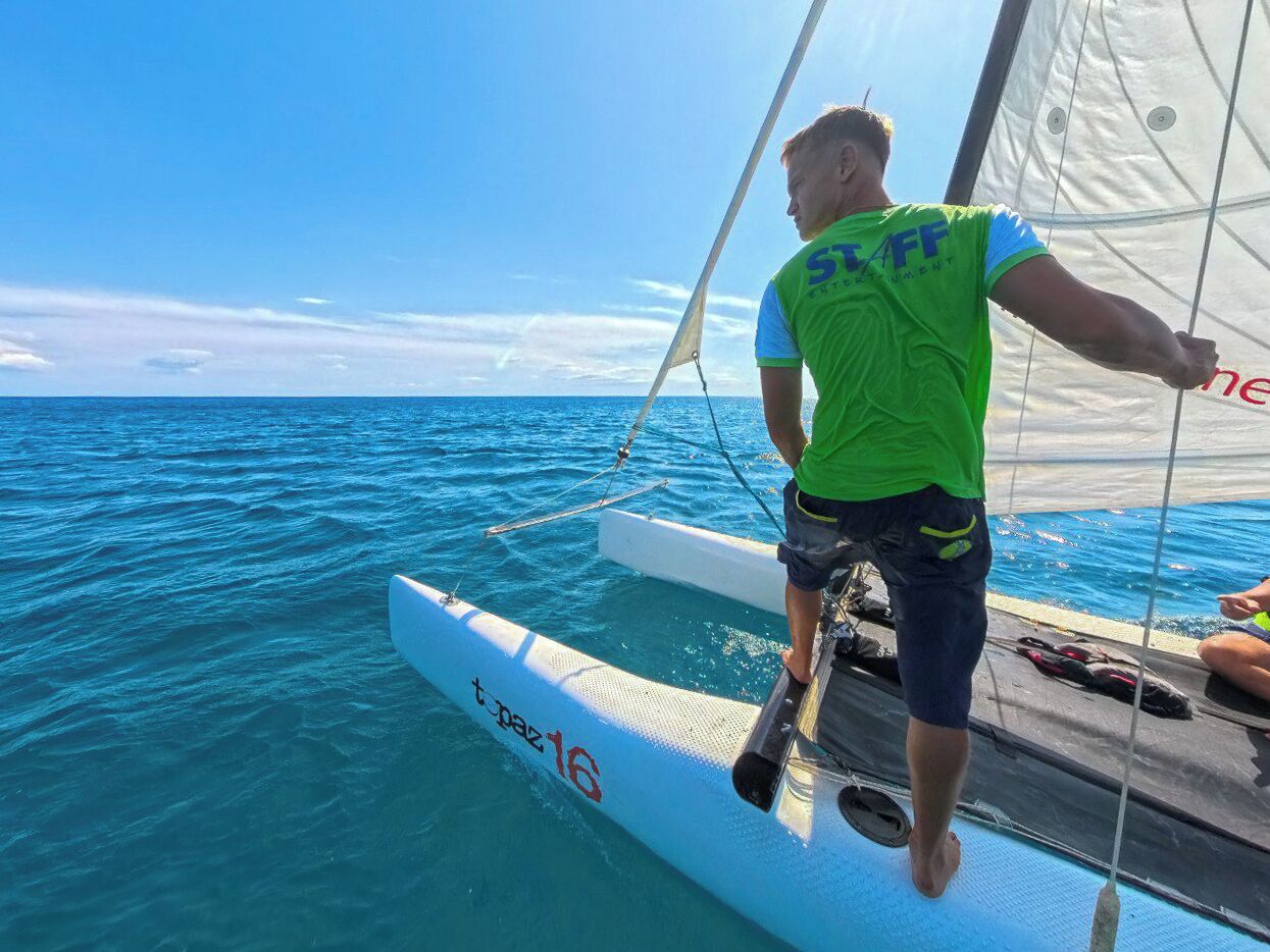 Una persona en un velero con una vista despejada del océano.