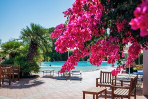 Zona junto a la piscina con sillas de descanso y vistas a la piscina y al océano.