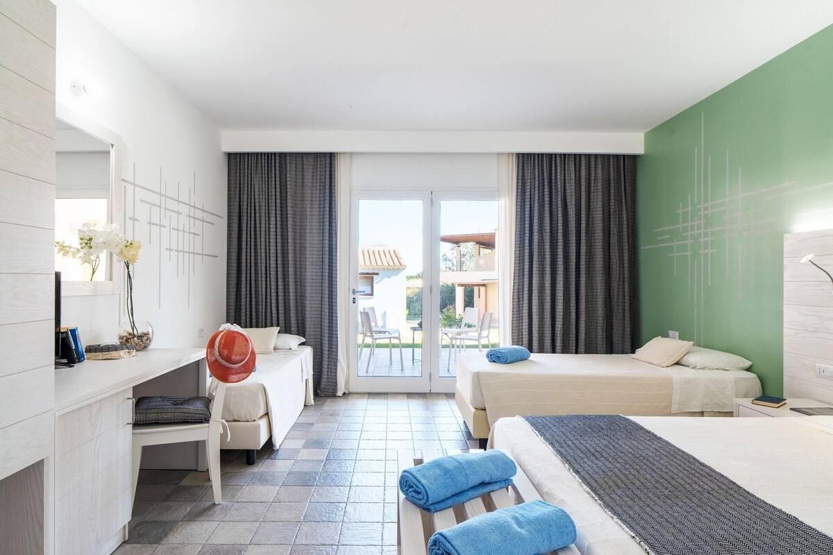 Ein Hotelzimmer mit Bett, Schreibtisch, Stuhl und Blick ins Freie.