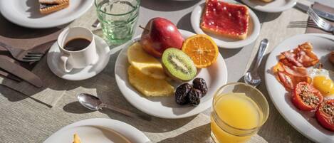 Desayuno servido con platos de comida, un vaso de jugo y una taza de café.
