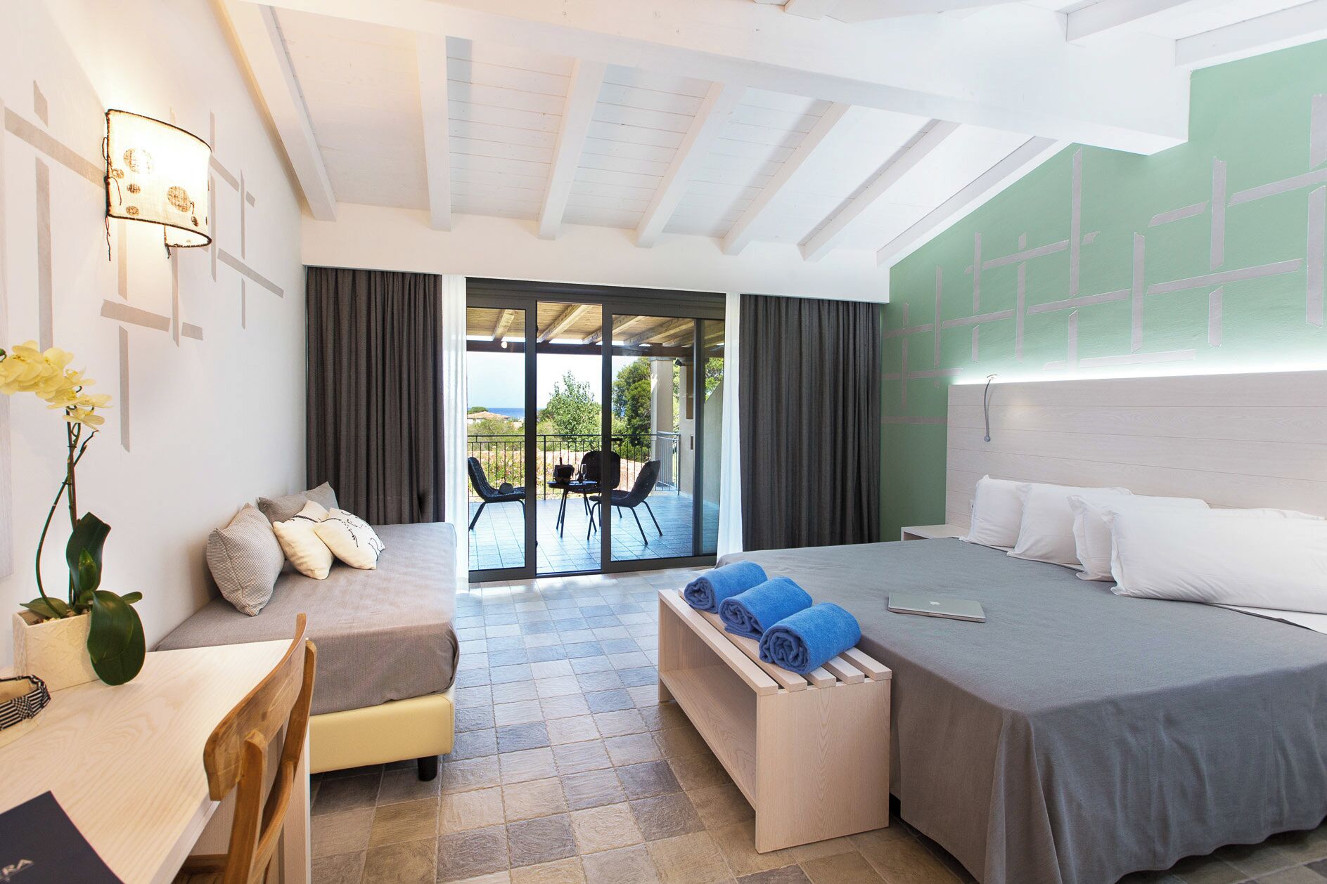 Une chambre d’hôtel comprenant un lit, un coin salon, un bureau et une vue sur l’extérieur.
