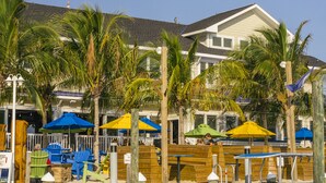A marina with a docked boat, wooden seating areas, and palm trees.