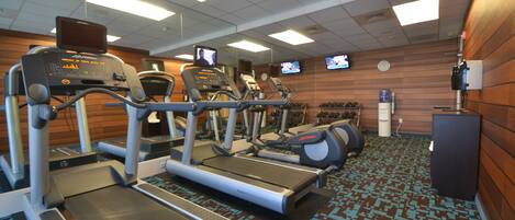 A gym with treadmills, elliptical machines, and stationary bikes.