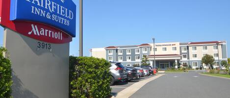 A Fairfield Inn & Suites Marriott sign, a parking lot, and a hotel building.