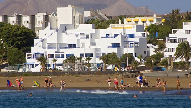 A coastal building complex with multiple white structures, some with balconies. - Apartamentos Club Pocillos (Tías)