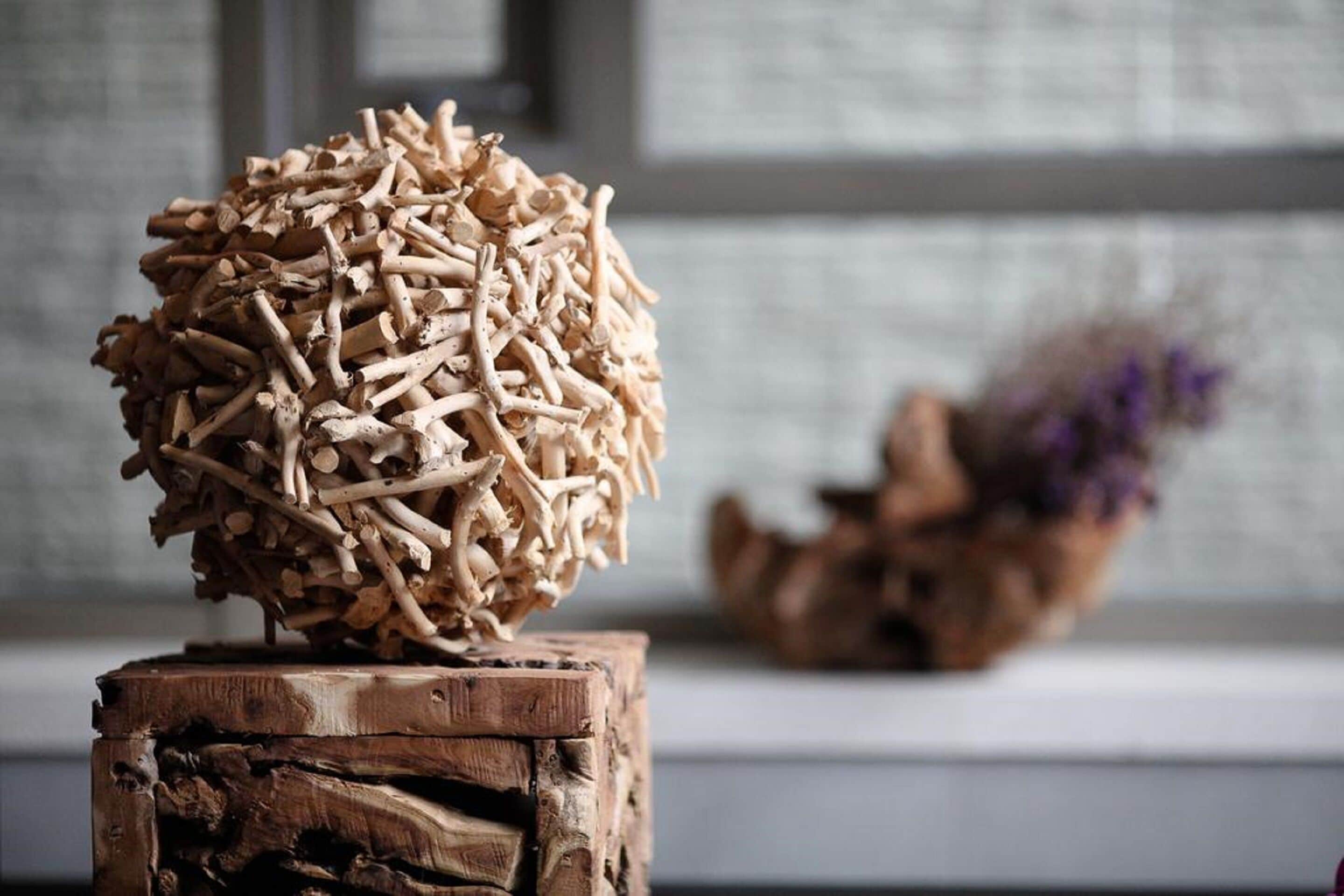 A wooden sculpture on a rustic wooden stool.