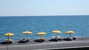 Una playa con sombrillas y sillas reclinables.