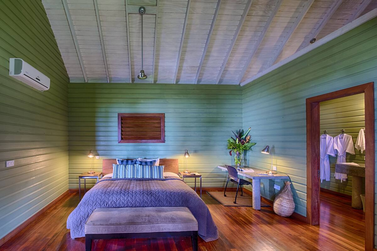 Une chambre à coucher avec un lit, des tables de chevet, un bureau et une chaise.