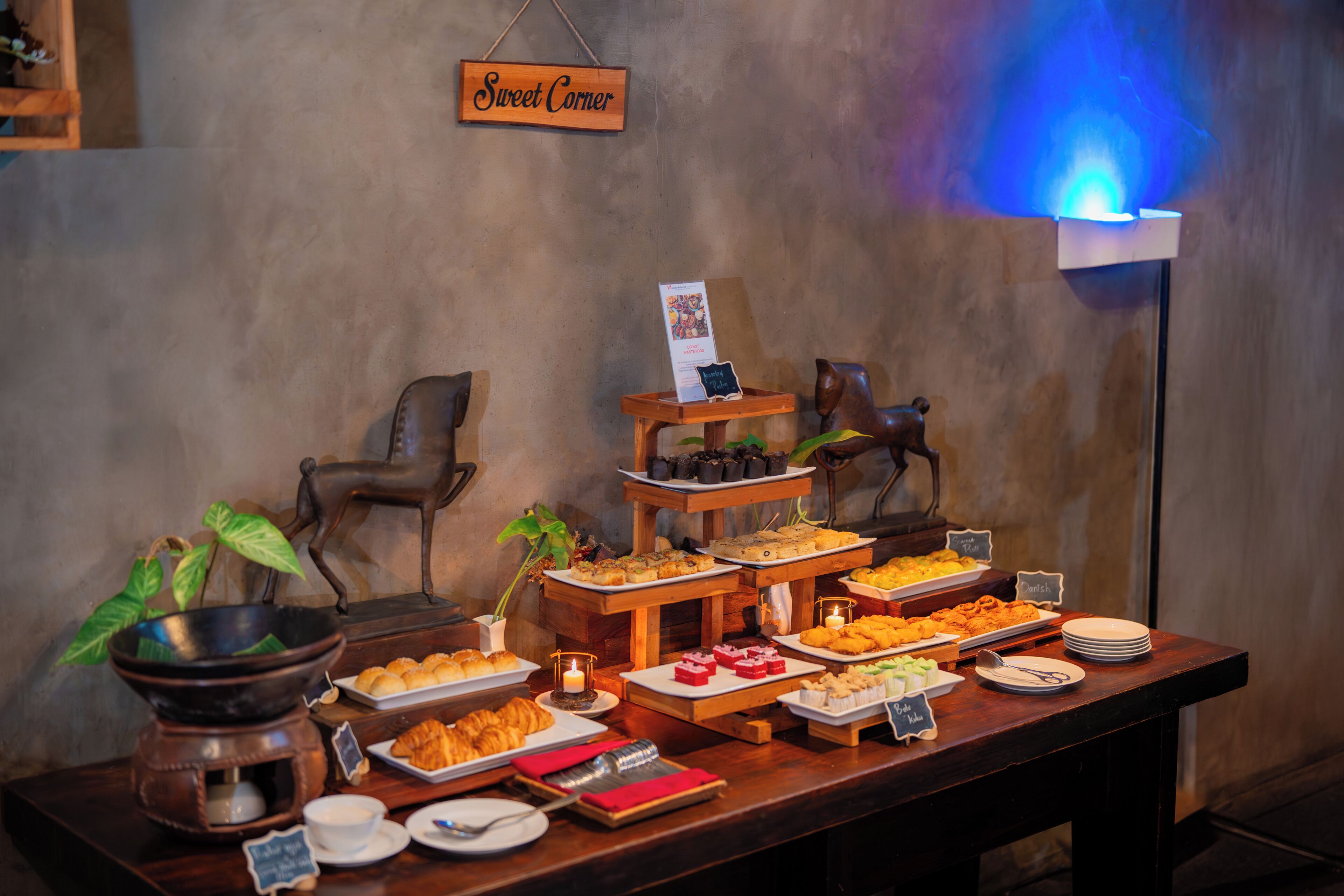 A buffet table with various food items and a sign reading "Sweet Corner".
