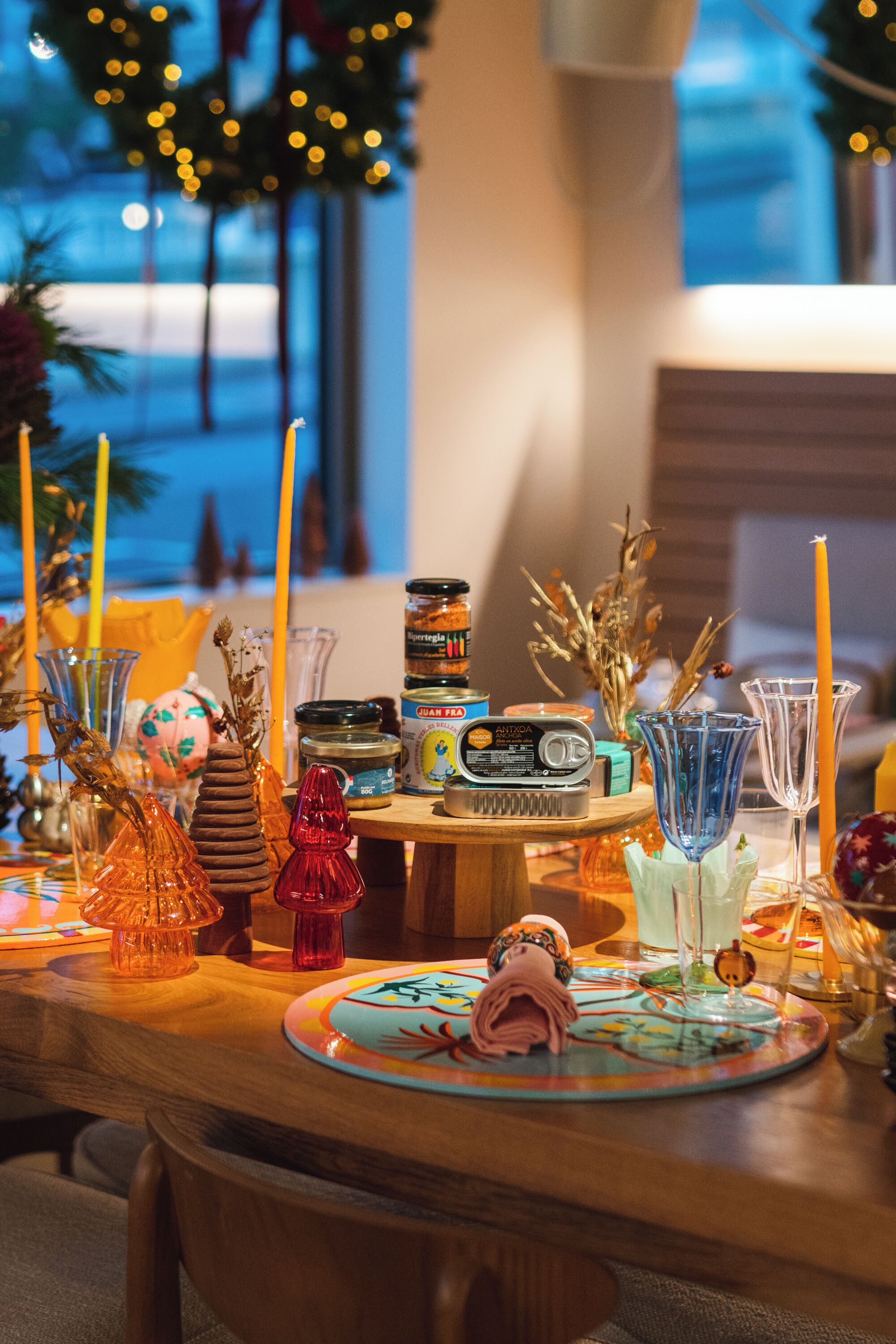 A table set with various decorative items, including candles, jars, and glassware, in a well-lit indoor setting.