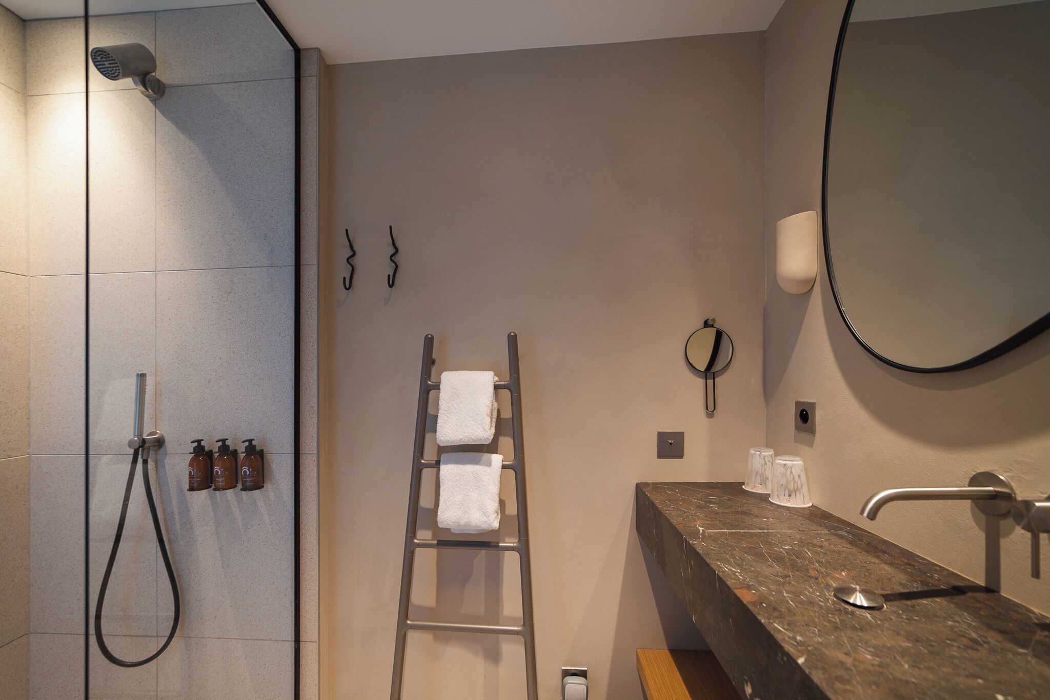 A modern bathroom with a shower, a vanity with a marble countertop, and a mirror.