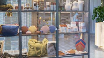 Une exposition de divers ustensiles de cuisine, notamment des casseroles, des poêles et des accessoires, disposés sur des étagères à l’intérieur d’une structure en treillis métallique.