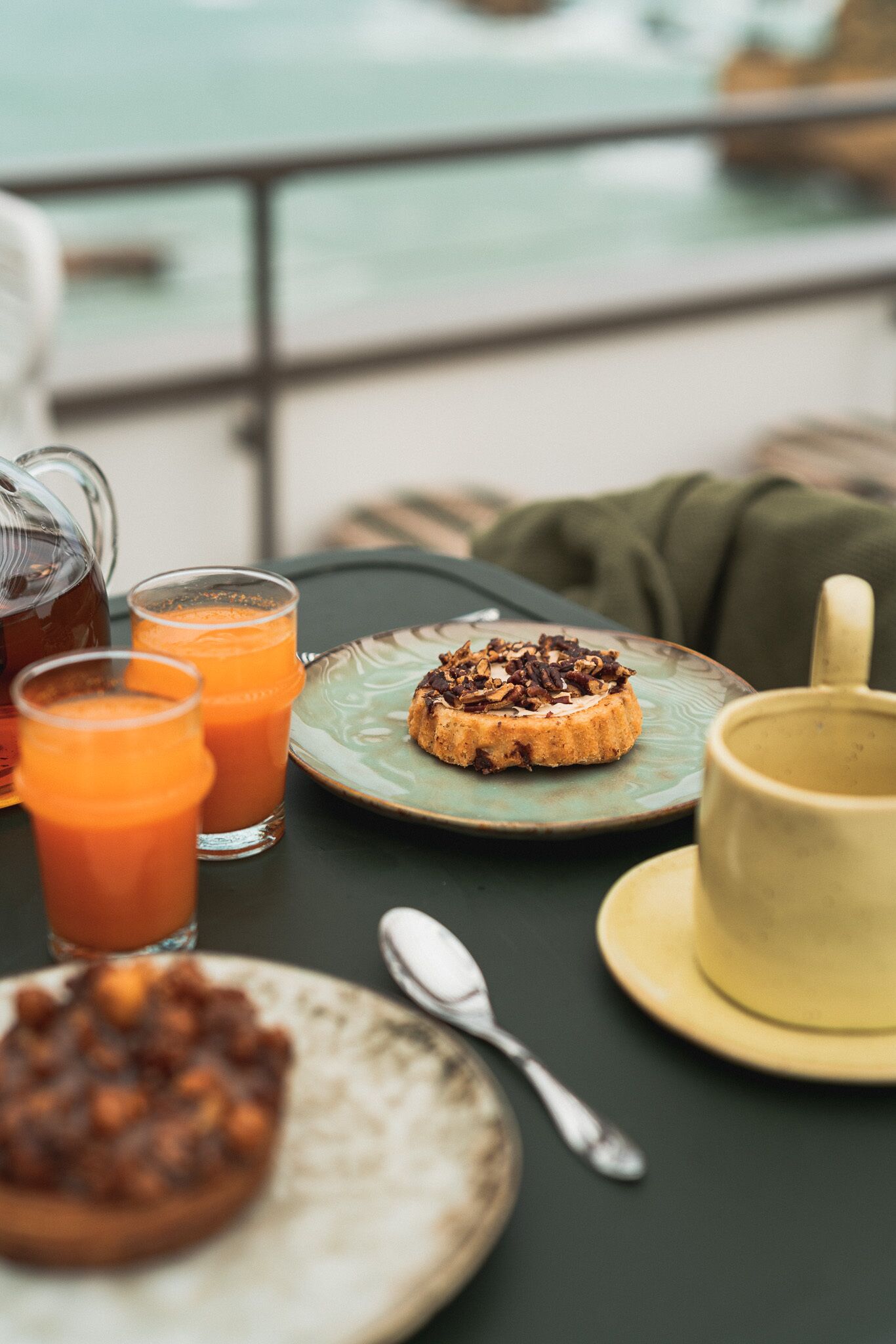 A table with a plate of food, a mug, and a glass of juice.