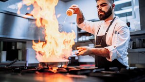 A chef cooking with flames on a stove in a professional kitchen. - Hotel de Charme Casa da Amieira (Santarém)
