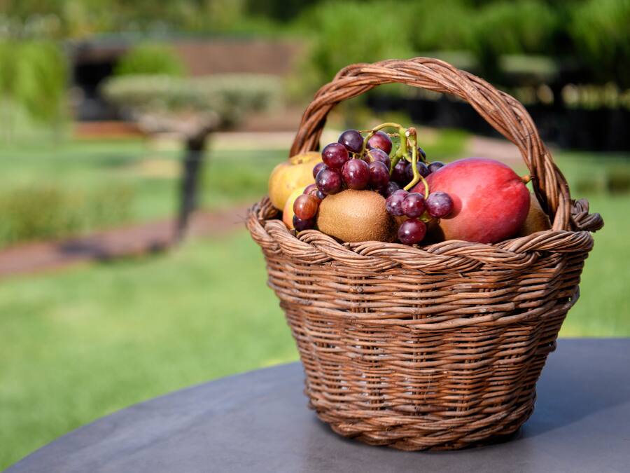 A wicker basket containing fruits on a table.
