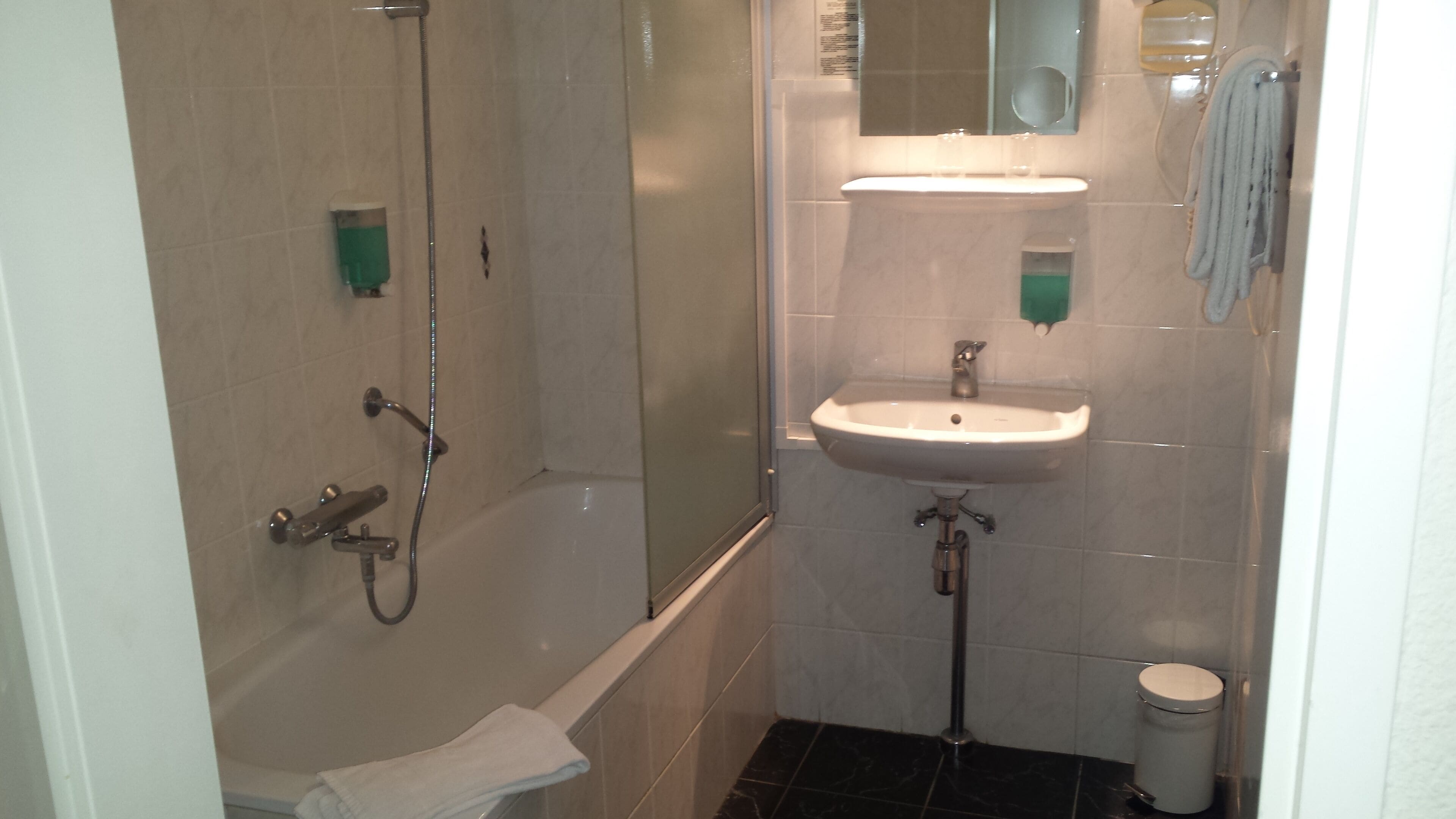 A bathroom with a shower, sink, and toilet.