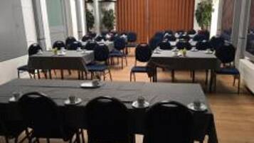 A dining area with tables and chairs arranged for a meal.