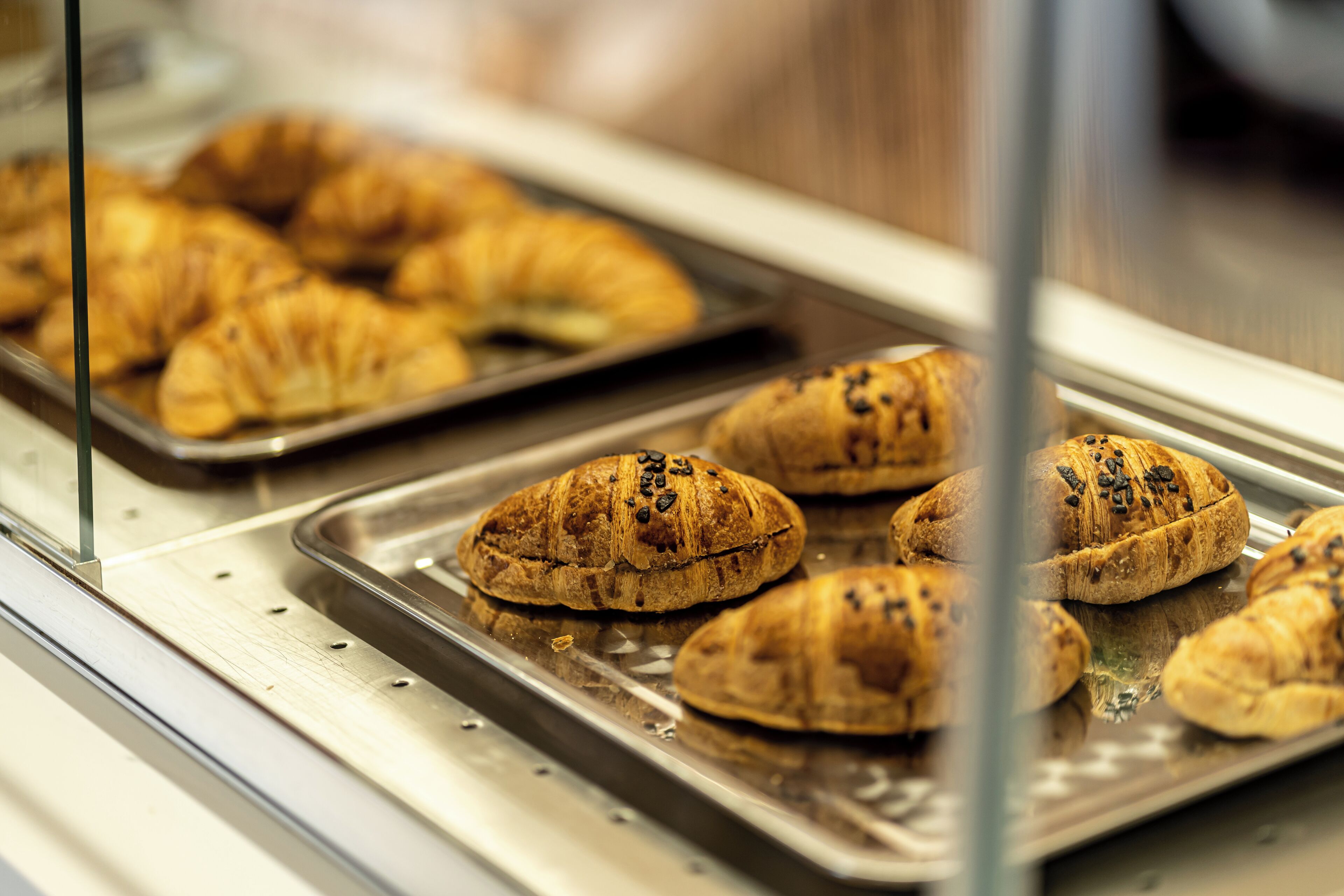 Una vitrina con productos horneados, incluyendo croissants y otras pastelerías.
