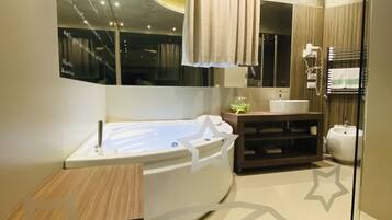 Ein modernes Badezimmer mit freistehender Badewanne, einem Waschtisch mit Spiegel und einem Handtuchhalter.