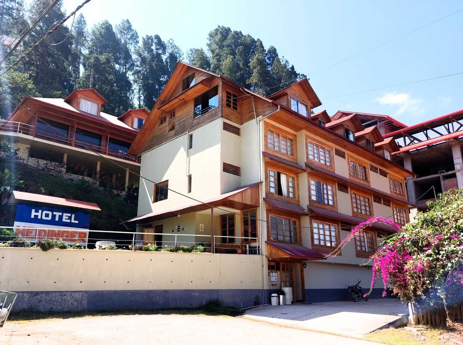 A multi-story hotel with a traditional architectural style, featuring balconies and large windows.