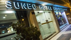 The exterior of the Sunec Hotel with its name illuminated in large letters. - Sunec Hotel (Chiclayo)