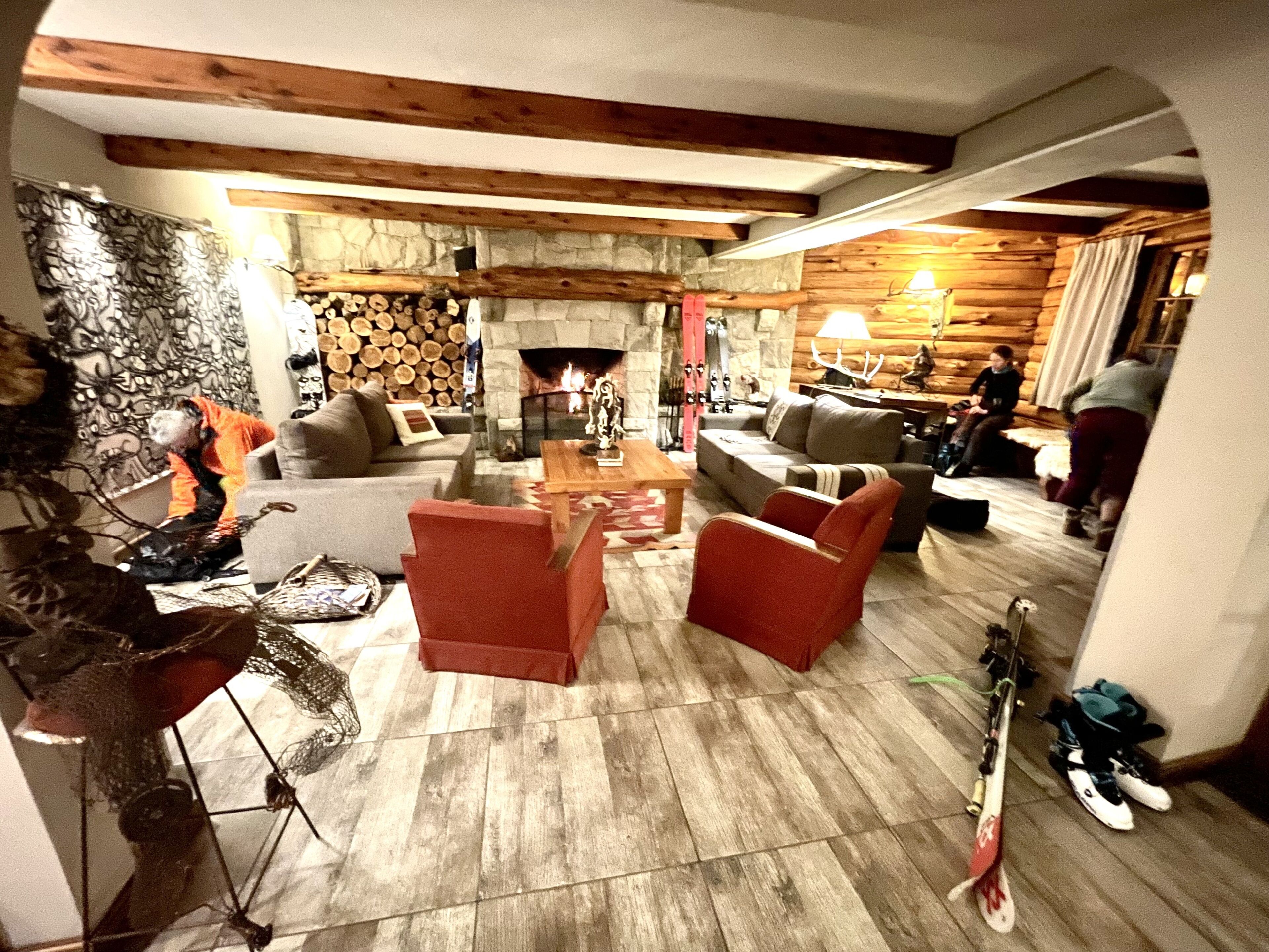 Ein gemütliches Wohnzimmer mit Kamin, Holzbalken und einer Steinwand.