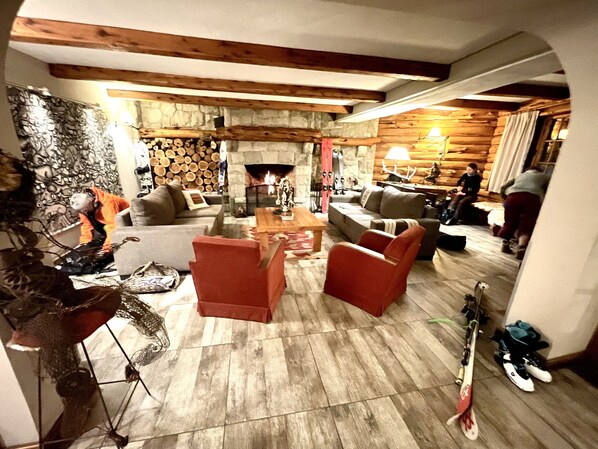 Una sala de estar acogedora con chimenea, vigas de madera y una pared de piedra.