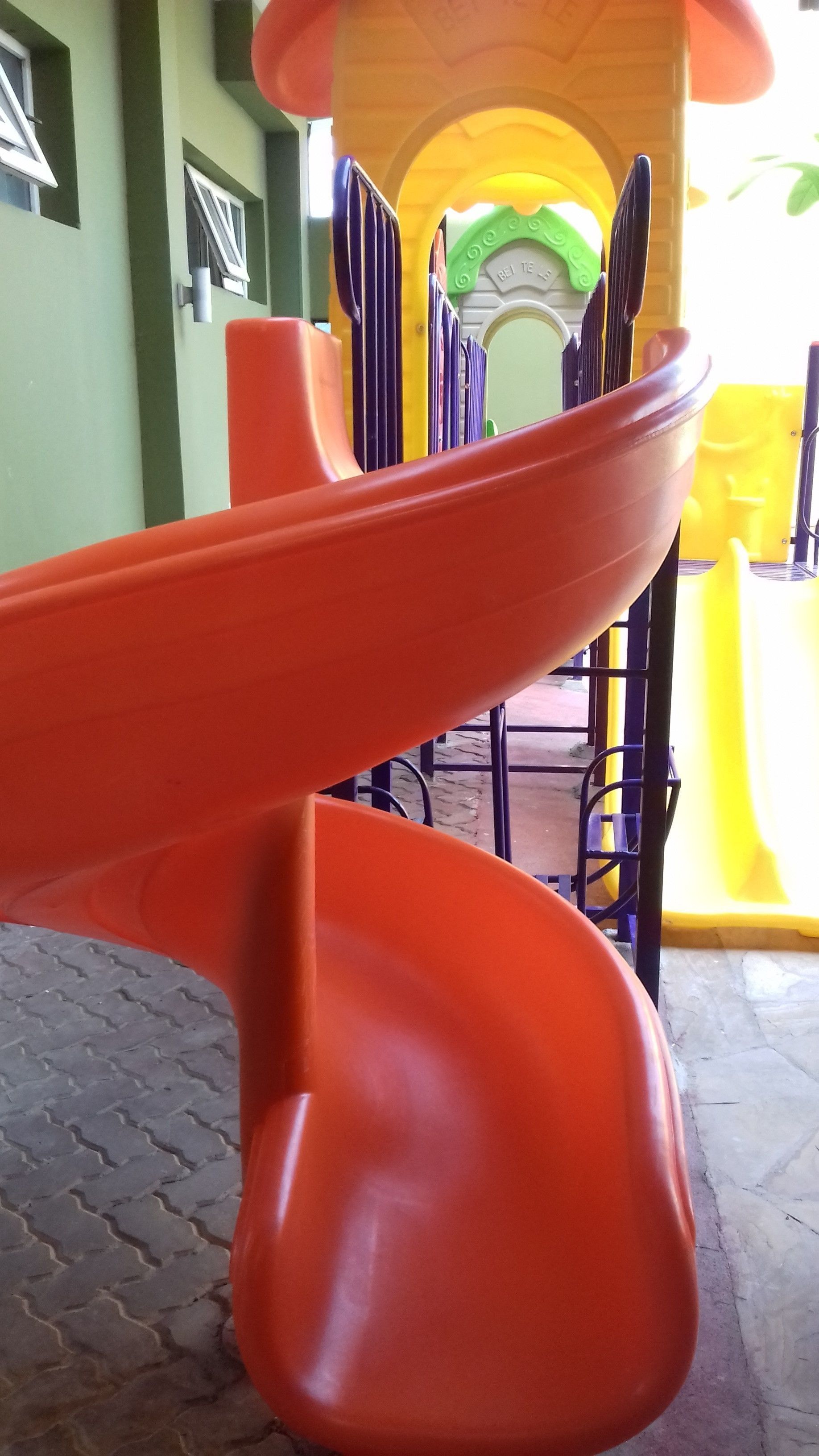 Un parque infantil con un tobogán rojo.