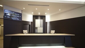 A reception desk with a digital display, a dark-colored counter, and a tiled floor. - Dormy Inn Express Sendai Hirosedori Hot Spring (Sendai)