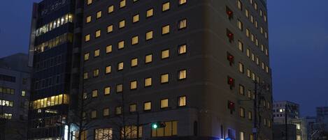 A hotel building with multiple floors, a prominent sign at the top, and a crosswalk in the foreground.