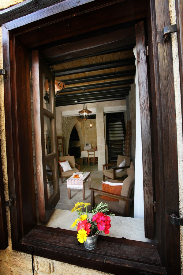 A cozy interior with a wooden bench, a table with a vase of flowers, and a fireplace.