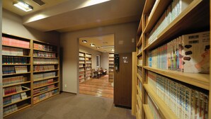 Una biblioteca con estanterías, un espacio de lectura y un cartel que indica una zona de descanso.