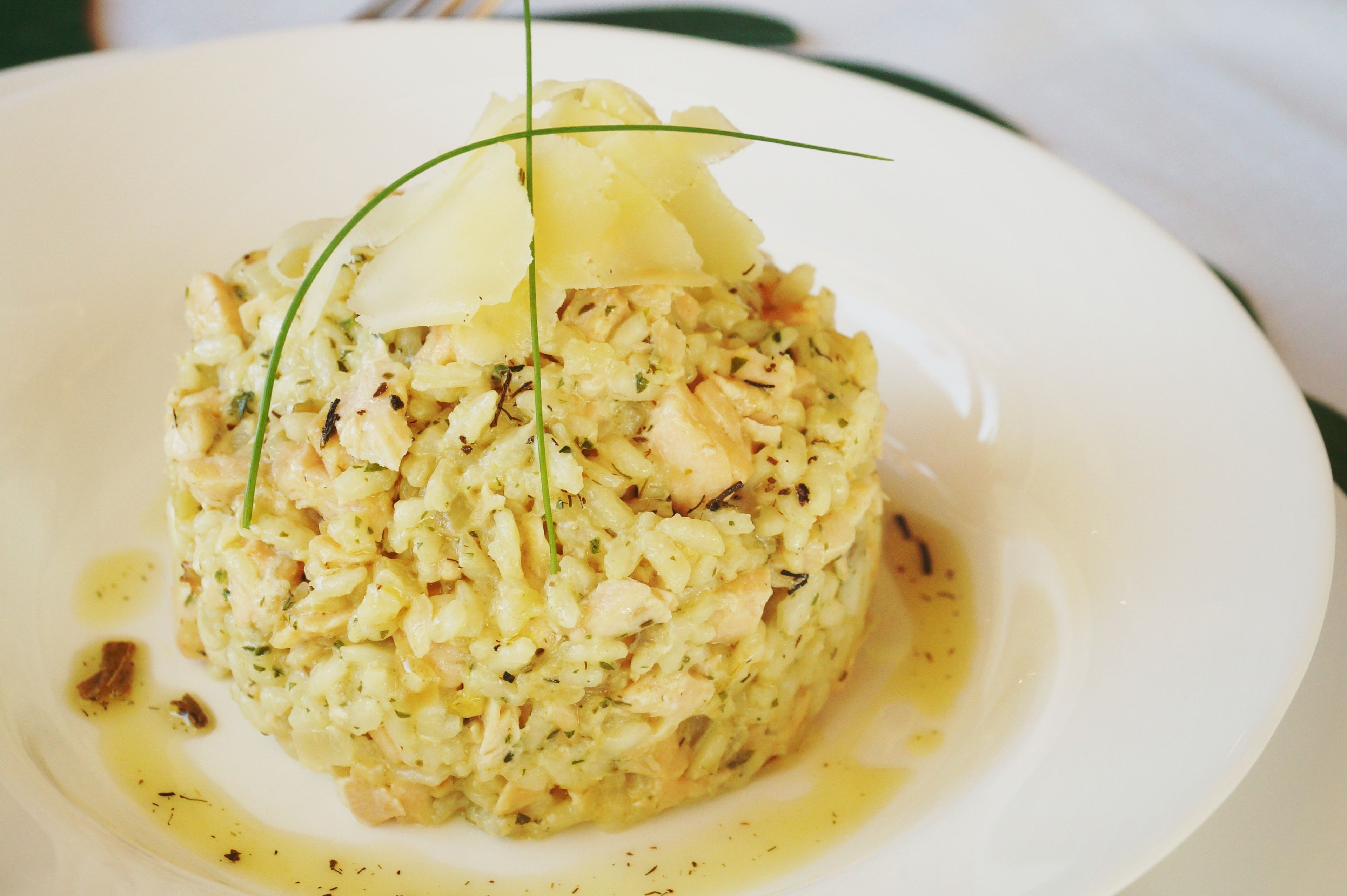 Une assiette de nourriture, garnie de ciboulette fraîche et surmontée d’un morceau de pomme de terre.