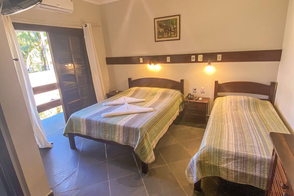 Ein Hotelzimmer mit zwei Betten, einem Deckenventilator und einem Bild an der Wand.