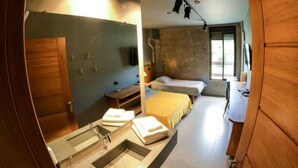Una habitación de hotel moderna con un espejo grande, un lavamanos, una cama, una mesita de noche y una ventana.