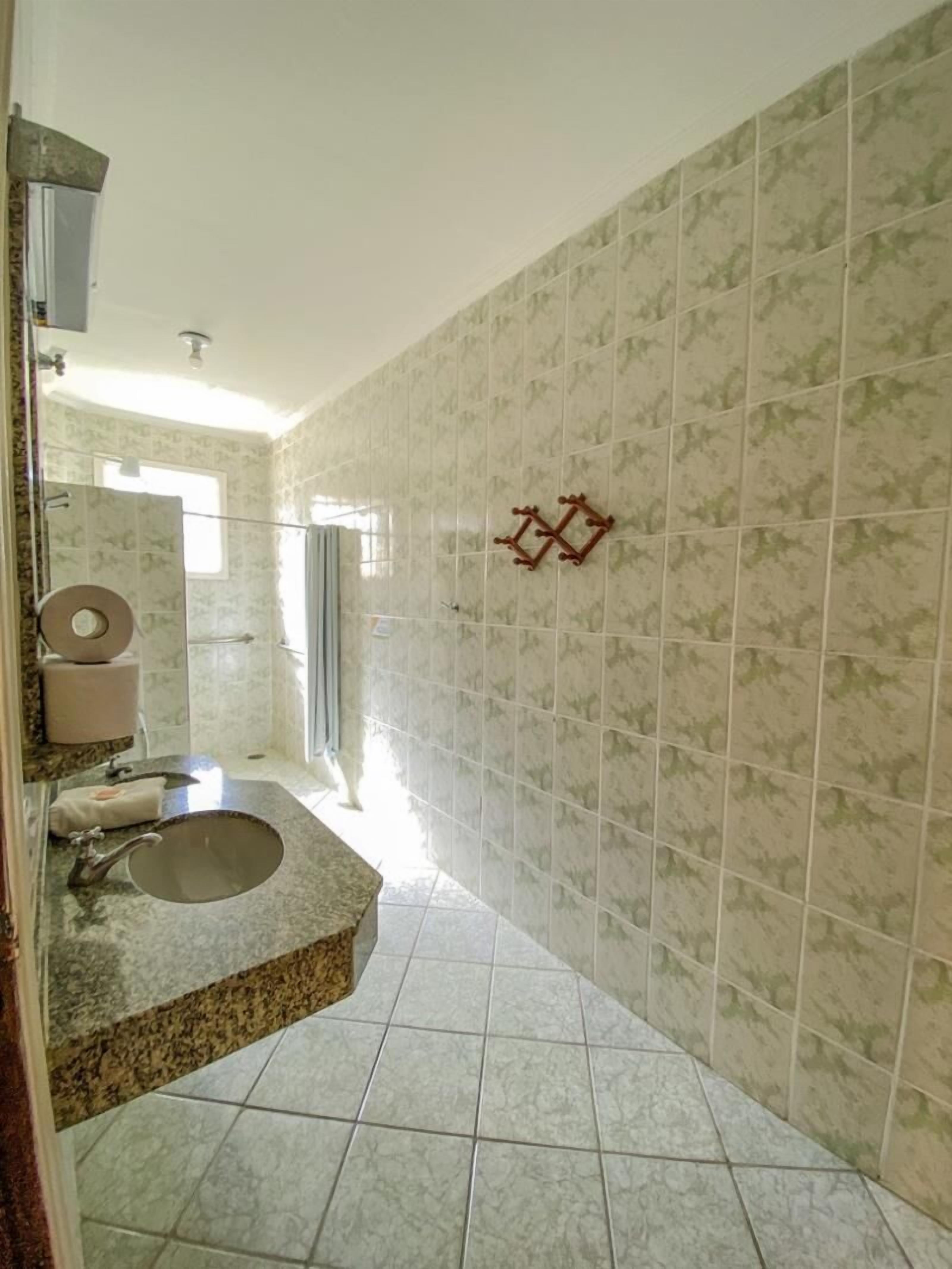 A bathroom with a sink, toilet, and shower area.