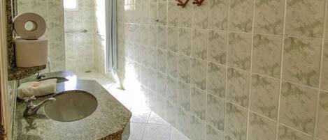 A bathroom with a sink, toilet, and shower area.