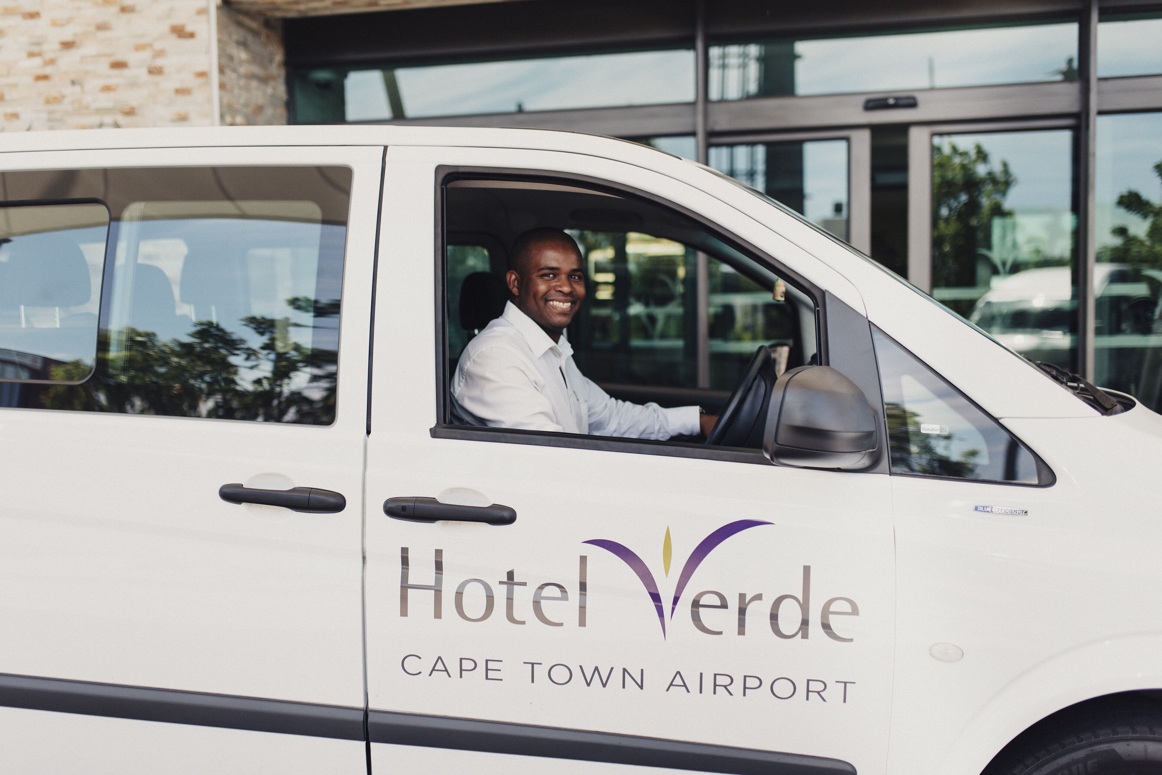 A white van with the text "Hotel Verde Cape Town Airport" on its side.