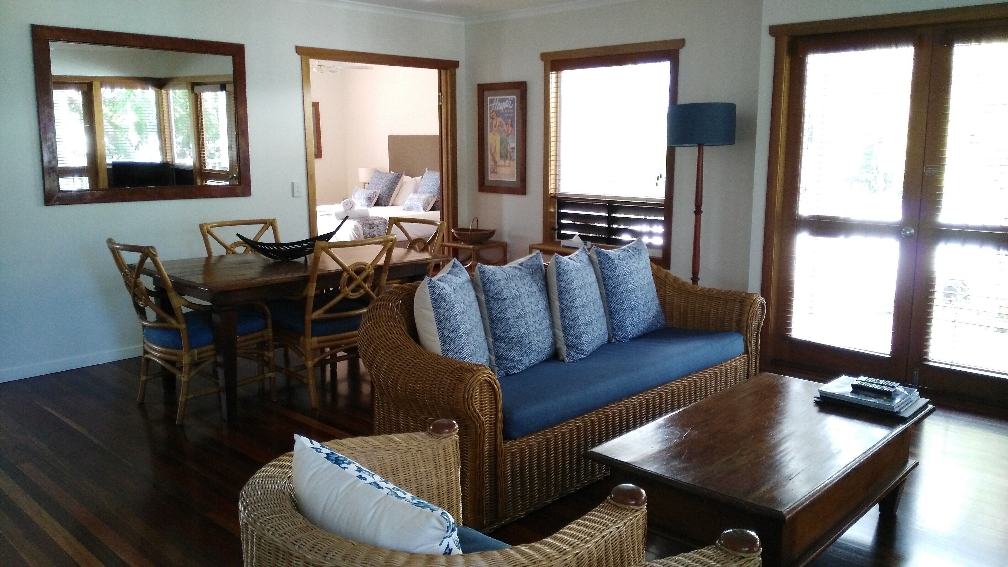 A living room with a sofa, chairs, a dining table, and a lamp.