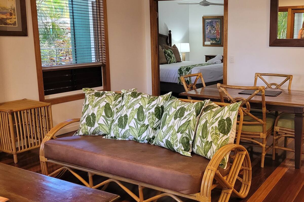 Una habitación con sofá, mesa de comedor, sillas y cama.