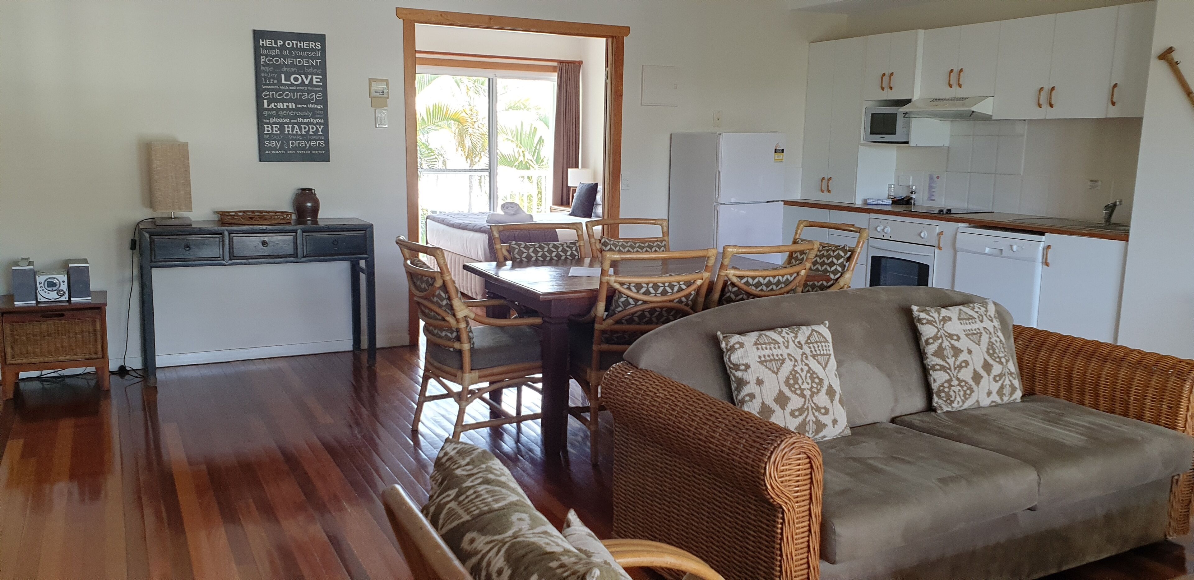 Un espacio habitable compacto con comedor, kitchenette y sofá.