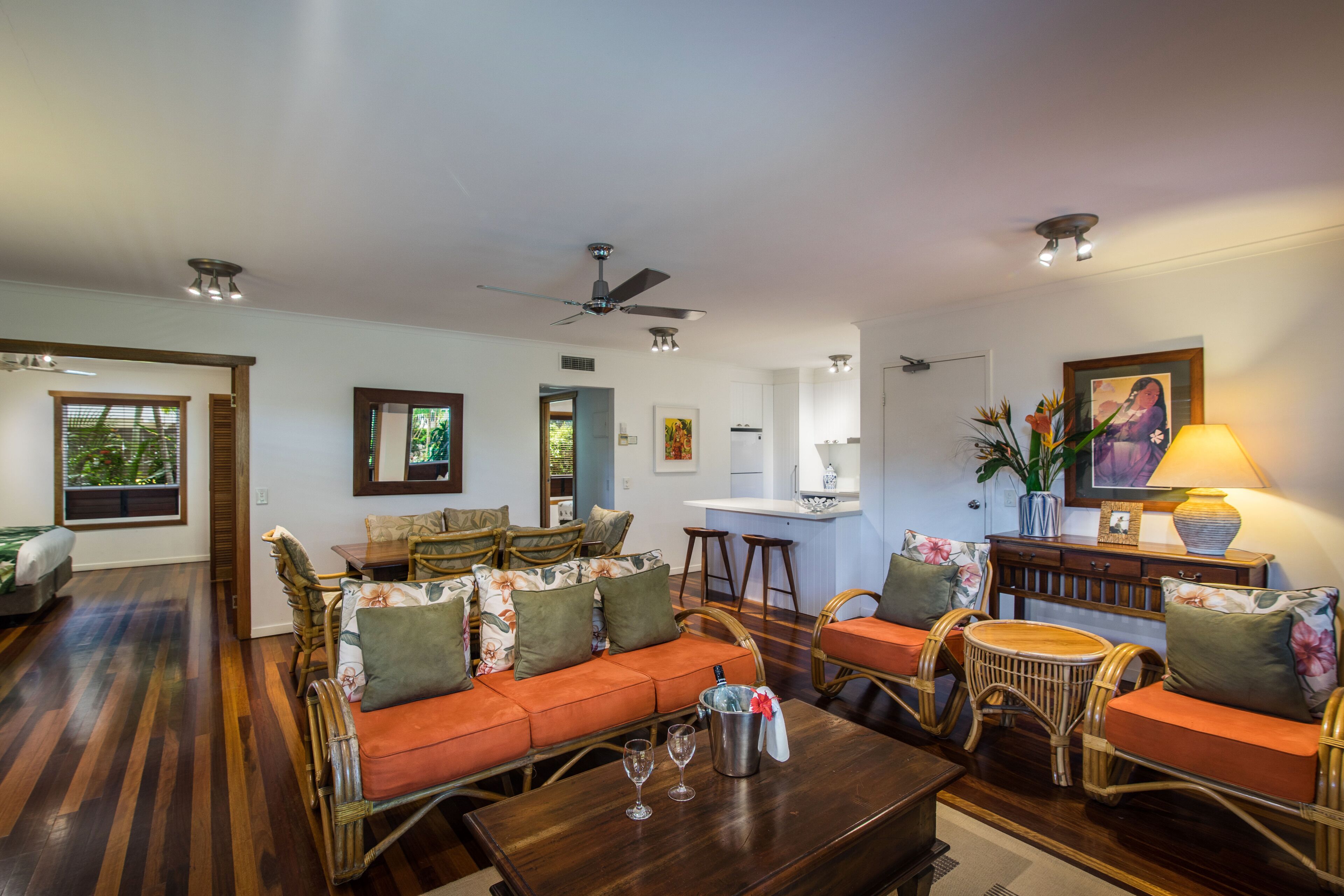 Uma sala de estar ampla com sofá, cadeiras, mesa de centro e espaço para refeições.