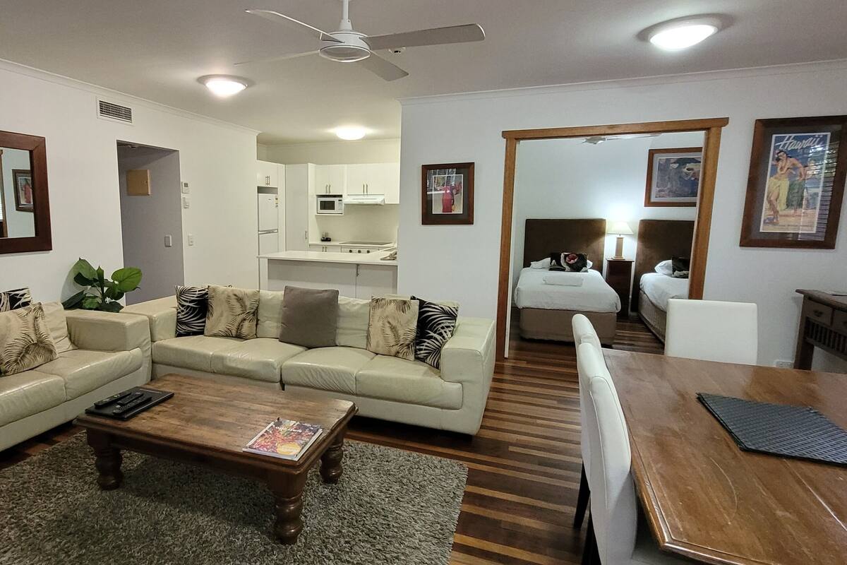 Una sala moderna con un conjunto de sofá, una mesa de centro de madera y una mesa de comedor.